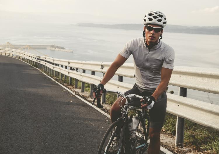 Cyclisme et vue : homme à vélo et portant de lunette de soleil couvrantes pour protéger ses yeux des éléments extérieurs